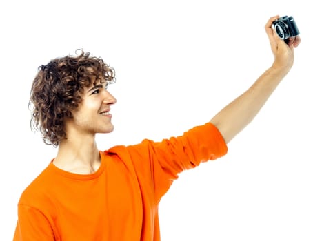 one young man caucasian holding camera photographing portrait in studio white background