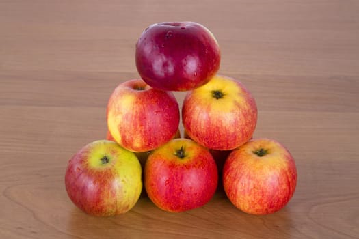 Pyramid of fresh apples on wooden background.