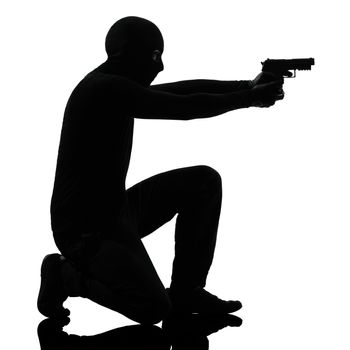 thief criminal terrorist man aiming gun in silhouette studio isolated on white background