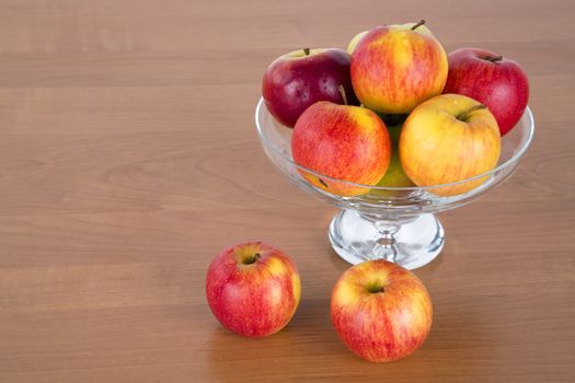 Apples in a glass on wooden background.