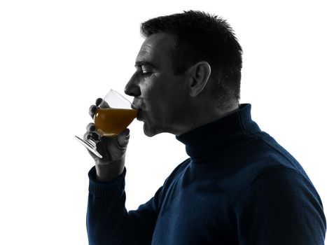 one caucasian man drinking orange juice portrait in silhouette studio isolated on white background