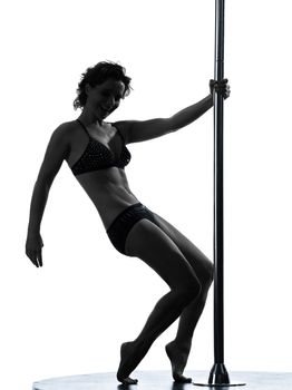 one caucasian woman pole dancer dancing in silhouette studio isolated on white background