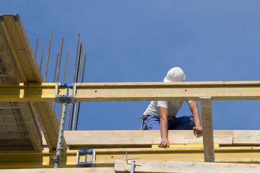 Worker controlling the level of wooden framework in a building under construction