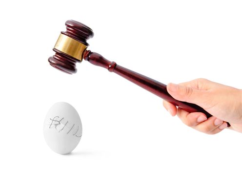 Gavel about to crush an eggshell stiched together with thread 