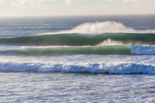 Morning ocean waves with shape and offshore winds crashing on shallow reefs.
