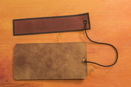 Card board and leather board tied with brown string on wooden background