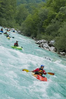 Line of kayakers on Soca river in Slovenia