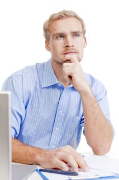 young man at desk in office thinking, contemplating