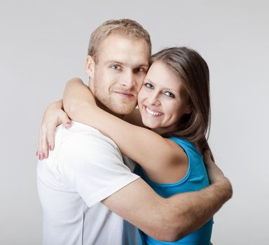 portrait of a happy young couple smiling, looking - isolated on gray