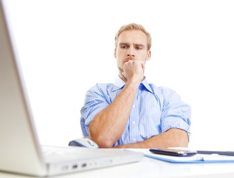 young man at desk in office thinking, contemplating