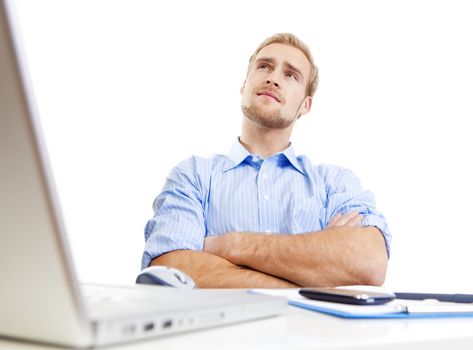 young man at desk in office thinking, contemplating