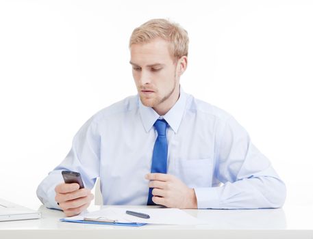young man at office reading text message on mobile phone