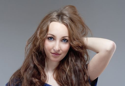 portrait of a young beautiful woman with brown hair - isolated on gray