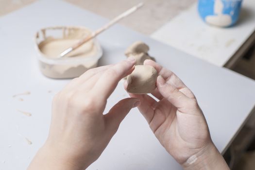 Girl make toyfrom clay. High resolution image.