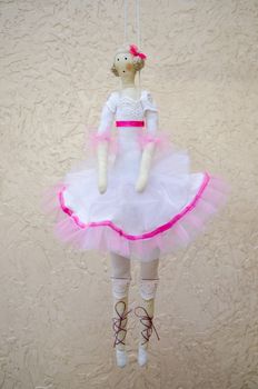 The handmade doll ballerina in white dress on the cord
