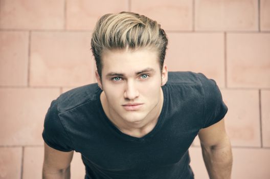Attractive blond young man shot from above, looking up towards camera