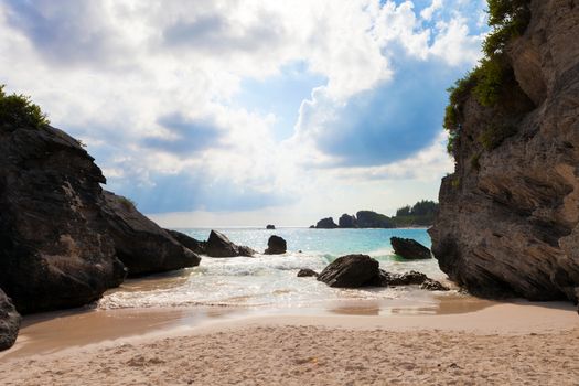 Horseshoe Bay Beach Bermuda with the sun shining in beams through the clouds.