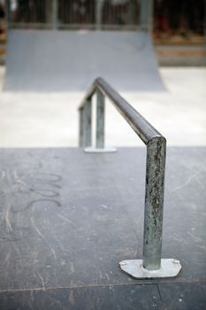 Closeup of a worn skate park grind rail with copy space.  Shallow depth of field. 