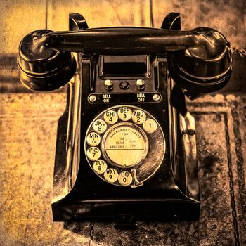 Detail monochrome view of old vintage dial telephone on the table