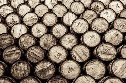 Detail monochrome view of stacked wine and whisky wooden barrels and casks
