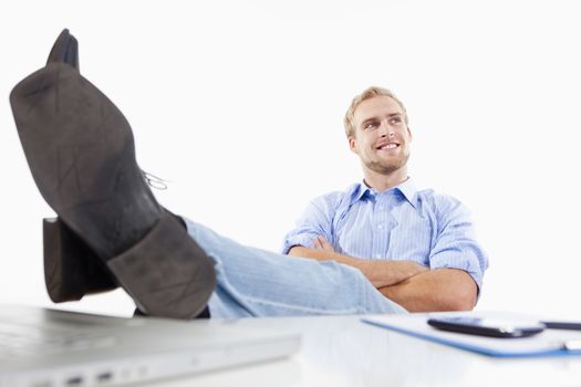 relaxed young man at office with his feet on the desk