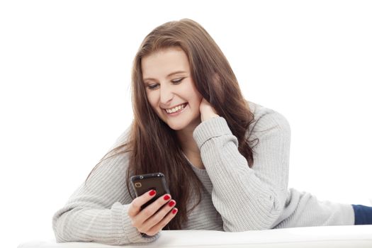 young girl reading text message on her phone, smiling