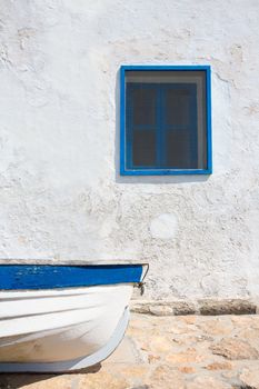 Mediterranean boat and whitewashed wall in white and blue at Balearic Islands