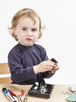 child repairing computer part. studio shot in light grey background