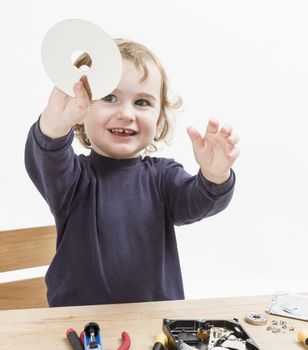 child repairing computer part. studio shot in light grey background