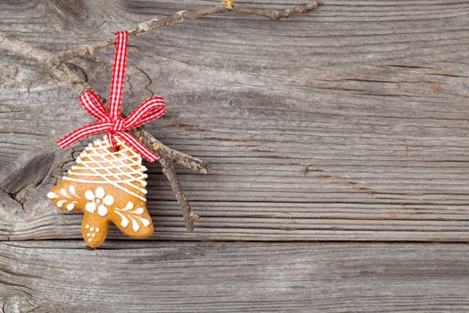 Gingerbread cookie hanging on wooden background. Christmas decoration.