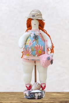 The Handmade doll plump woman in a bathing suit and a straw hat on a stand made of shells