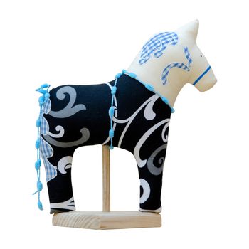 The Hand made soft toy horse isolated on black with blue on the stand