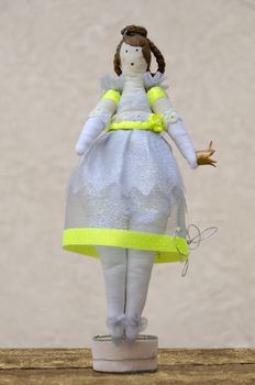 The handmade doll plump princess with a crown in the hands of the stand