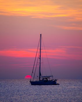 Ibiza sunset sun view from formentera Island with sailboat in Balearic Islands