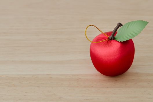 Fake red Cherry and green Leaf on Wood Table Background