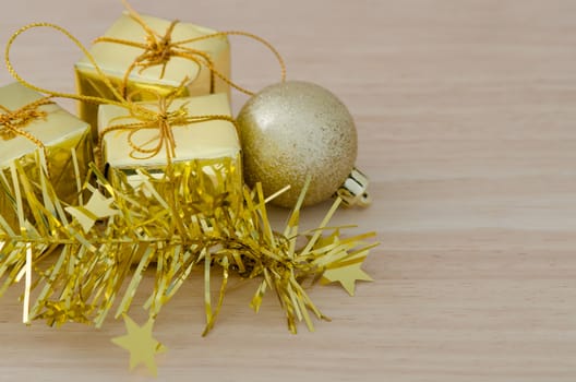 Gold Christmas bauble and Three Present Boxes on Wood Table Background