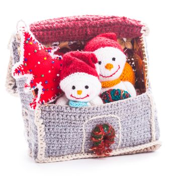 Two knitted christmas  snowmen in a house and handmade christmas tree