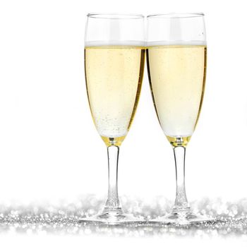 Two champagne flutes and decoration on gold shiny background