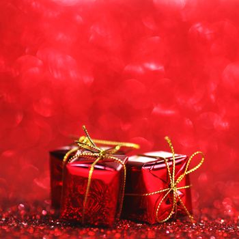 Red Christmas gift boxes on shiny glitter background