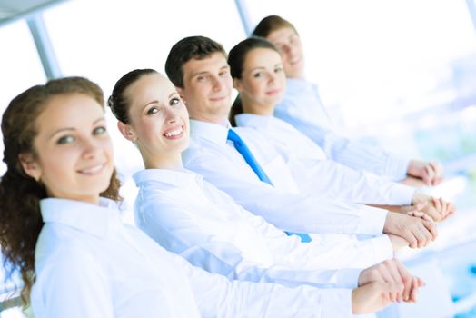 young business people holding hands, standing in a row, the concept of teamwork