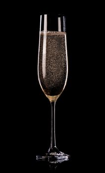 Glass of champagne with bubbles on black background