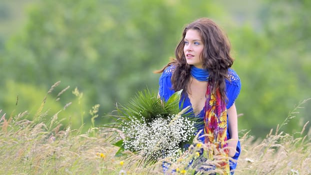 girl with bouquet of white flowers in green field