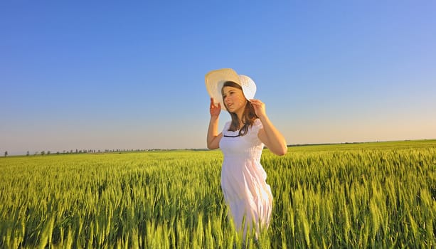 beautiful girl with hat in wheat field