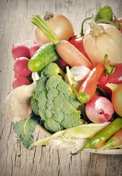 Fresh vegetables in  basket on wooden table