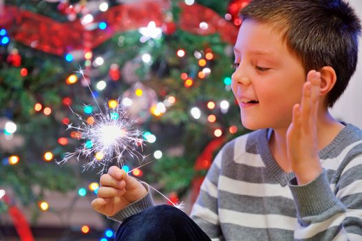 christmas and portrait of boy looking at  fire sparks 