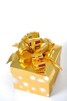 Golden gift box with golden ribbon on white background