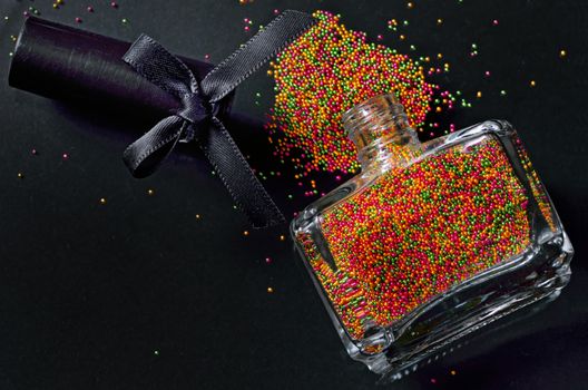 Bottle with colorful nail polish on black background