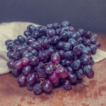 bunch or red grapes on a wood surface