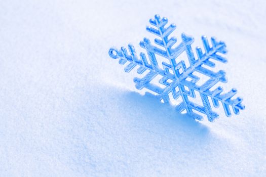 Snowflake on the snow. White xmas holiday background.