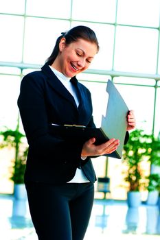 Young happy business woman with an open folder in hand